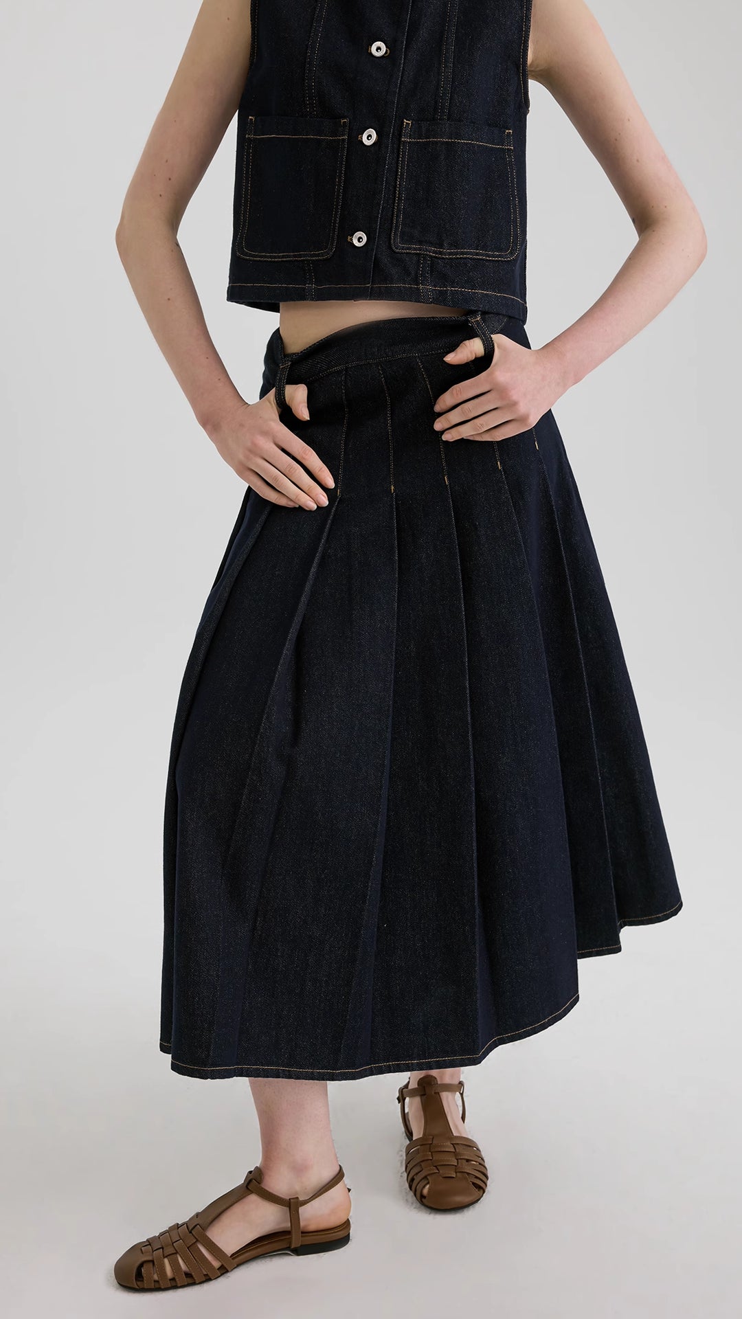 Denim A-line pleated skirt layered with a denim vest set